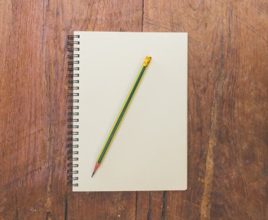 kitap ve ahşap masa üzerinde kalem