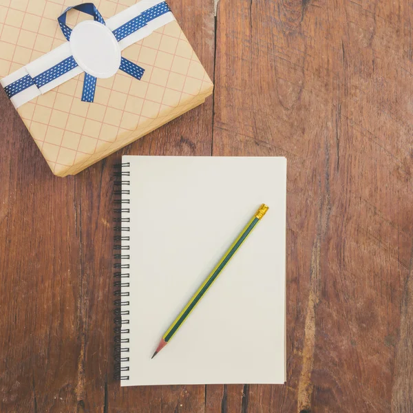 Vintage-Geschenkbox auf Holz-Hintergrund mit Notizbuch und Bleistift. — Stockfoto