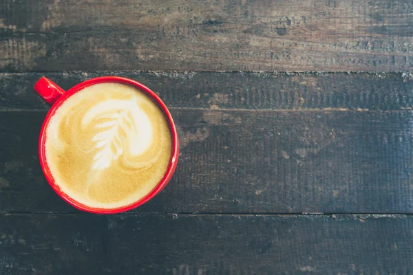 Tazza rossa e caffè latte sul tavolo di legno — Foto Stock