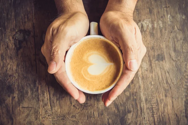 Man met warme kop van koffie, met hart vorm — Stockfoto