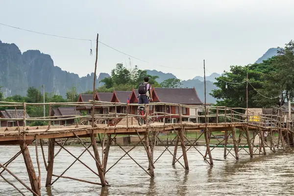 Wooden bridge over river song to riverside guesthouse, Vang vien — Stock Photo, Image