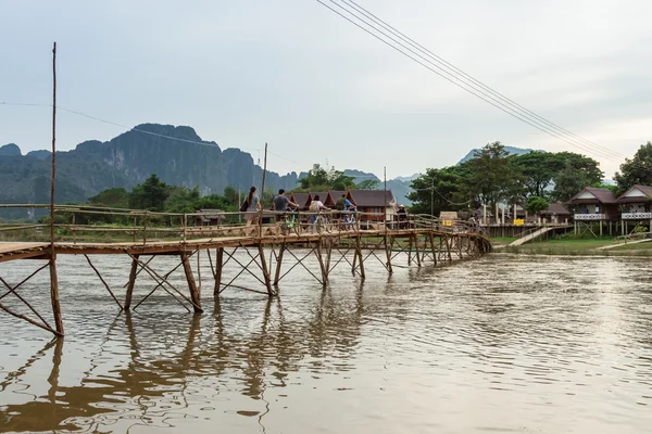 Wooden bridge over river song to riverside guesthouse, Vang vien — Stock Photo, Image