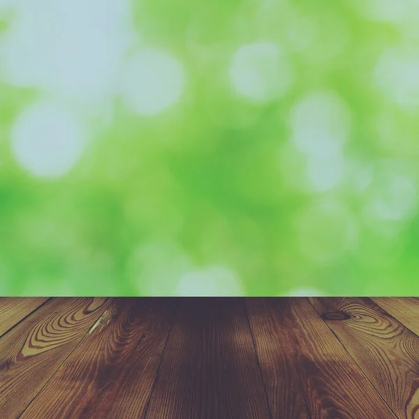 Mesa de madeira e bokeh abstrato natureza verde fundo com vinta — Fotografia de Stock