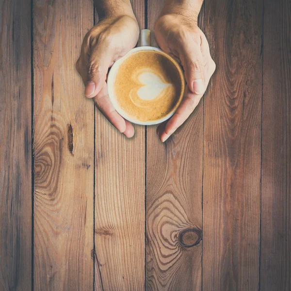 Mano dell'uomo che tiene la tazza calda di caffè, con forma di cuore — Foto Stock