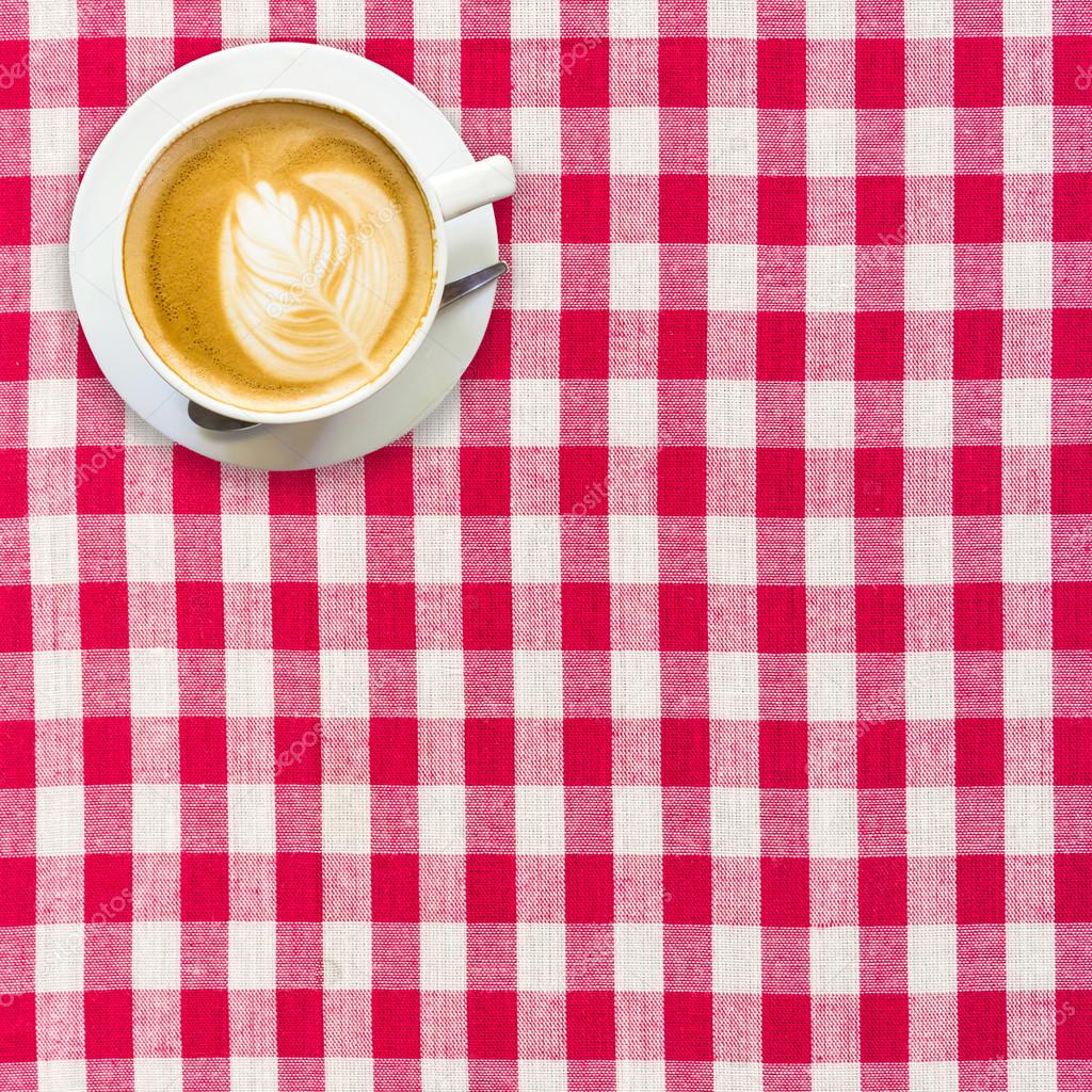 cappuccino coffee on white and red checkered background close up