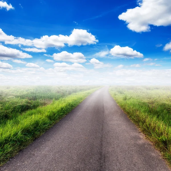 Estrada rural no campo e céu azul com nuvens brancas — Fotografia de Stock