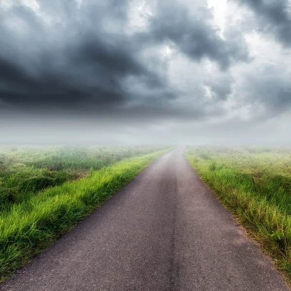 País estrada no campo e nuvens de tempestade ou nuvens de chuva — Fotografia de Stock
