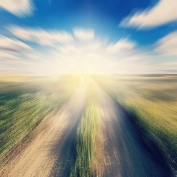 Vintage photo of road in country and field motion blur with sunl — Stock Photo, Image