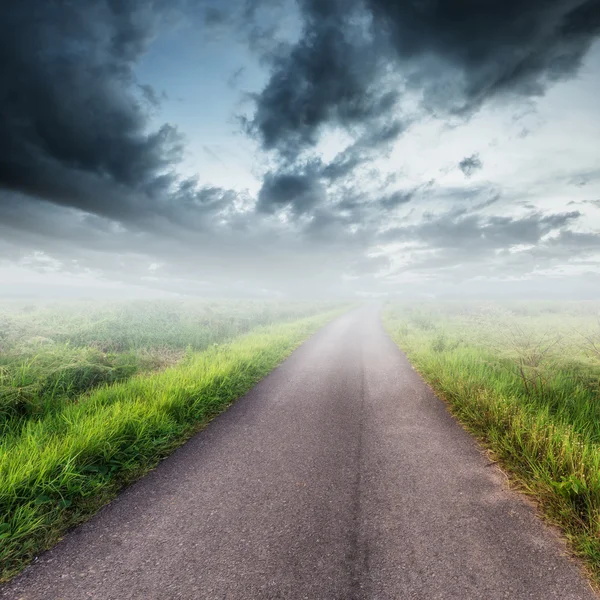 Country road  on field and blue sky with clouds — Stock Photo, Image