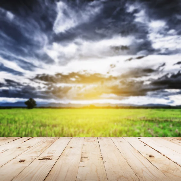 Abstract blurred field and sunlight with wood table — Stock Photo, Image