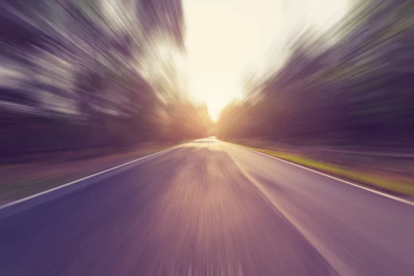 Estrada de asfalto vazia em movimento borrão e luz solar com tom vintage — Fotografia de Stock