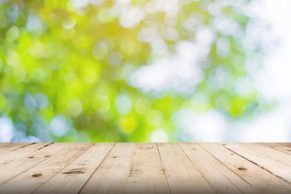 Grünes Blatt Bokeh verschwommen und Holz Tisch für Natur Hintergrund — Stockfoto