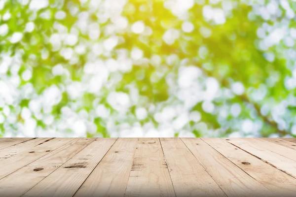 Hoja verde bokeh borrosa y mesa de madera para fondo de la naturaleza — Foto de Stock