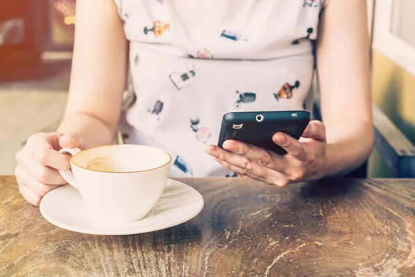 Közelkép a kéz asszony coffee shop-val mélység-ból-a telefon használata — Stock Fotó