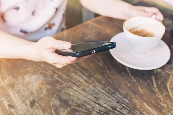 Närbild på händer kvinnan med telefonen i kafé med djup — Stockfoto