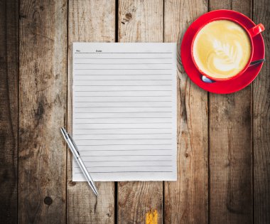boş kağıt ve kalem ile ahşap masa arka plan üzerinde kırmızı fincan kahve
