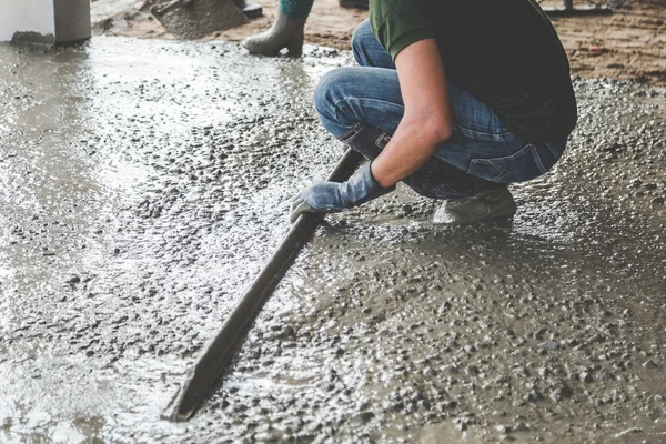 Mason construindo uma betonilha de cimento casaco — Fotografia de Stock