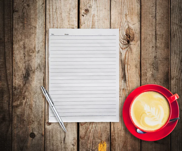 Papier vide et stylo avec café tasse rouge sur fond de table en bois — Photo