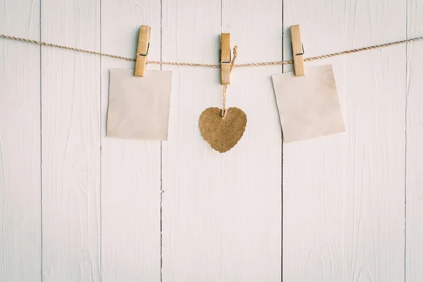 Two blank old paper and brown heart hanging. On white wooden bac — Stock Photo, Image