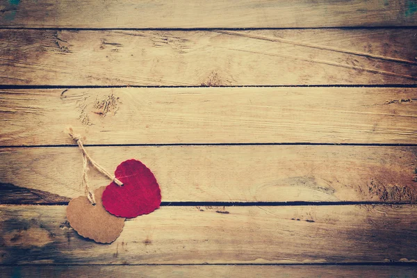 Two red and brown heart on wooden background with vintage style. — Stock Photo, Image