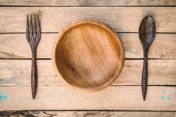 Drewniane miski i łyżką, widelcem na tle drewna — Zdjęcie stockowe