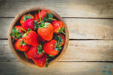 Ahşap arka plan üzerinde kase çilek kapatın