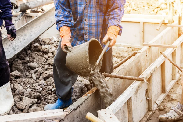 Pracovník směšovací cementové malty sádrové stavební s vinobr — Stock fotografie