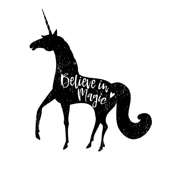 Croyez en la magie. Texte calligraphique avec silhouette noire dessinée à la main de licorne. Illustration vectorielle arrière plan . — Image vectorielle