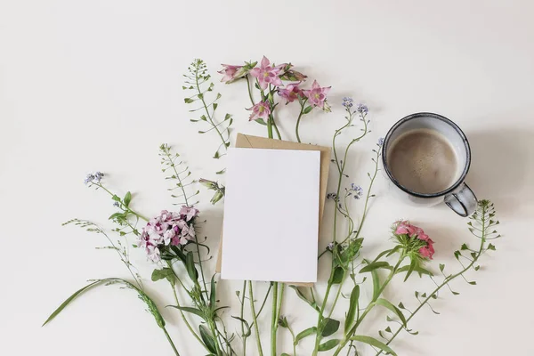 Sommergrüßkarte, Einladungsattrappe. Garten- und Wiesenblumen. Florales Banner und Tasse Kaffee. Hirtentasche, Dianthus und Aquilegia Pflanzen isoliert auf weißem Tischhintergrund. Flache Lage. — Stockfoto