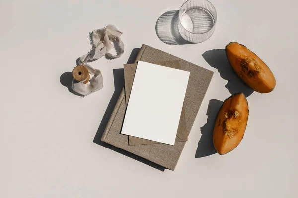 Summer food still life composition. Cantaloupe melon fruit. Beige table background. Stationery mock up scene. Blank paper card, invitation. Glass of water, cocktail and old book in sunlight. Flat lay — Stock Photo, Image