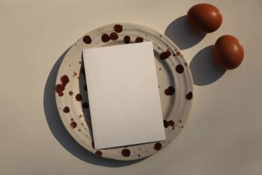 Seramik Tabakta Kahverengi lekeli Boş Kutlama Kartı ile Minimal Food Concept Still Life, Eggs. Yaratıcı Yemek Pişirme Arkaplanı, Tarif Mokikatı, Modern Editoryal Paskalya Düzlüğü. Üst Görünüm.