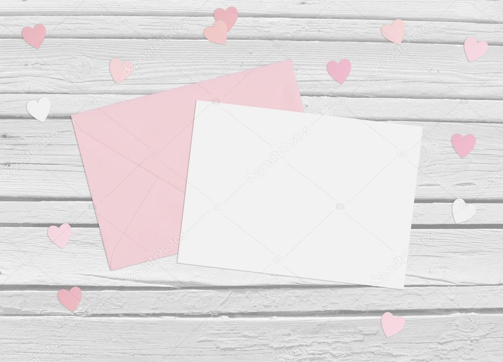 Valentines day or wedding mockup scene with envelope, blank card, paper hearts confetti and wooden background