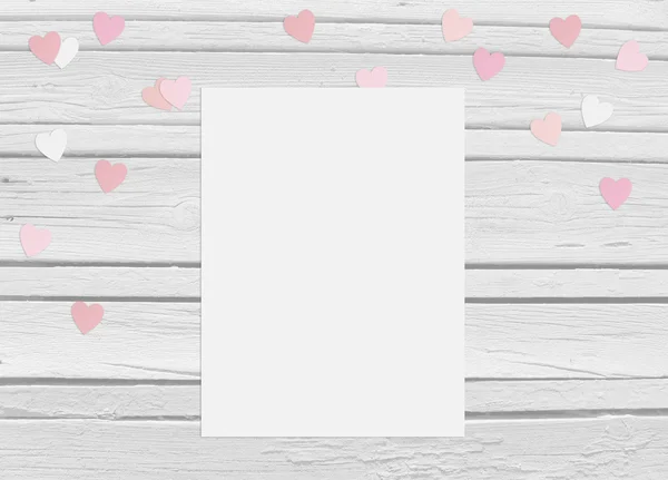 Valentýn nebo svatební maketa scéna s prázdnou kartou, papírové konfety srdce a dřevěné pozadí — Stock fotografie