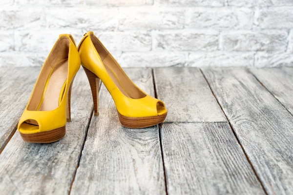 Pair of woman shoes on a wooden floor and free space. — Stockfoto