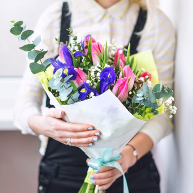 Florist hands showing bouquet of spring flowers. Selective focus.