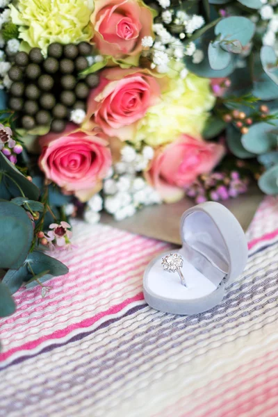 Anillo de compromiso en la caja sobre fondo de flores borrosas . —  Fotos de Stock