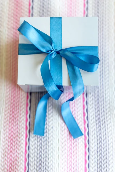 Scatola regalo con fiocco blu su sfondo tessile carino . — Foto Stock