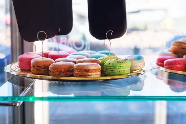 Traditional french colorful macaroons in confectionery shop. Display of delicious pastries in a bakery. — Stockfoto