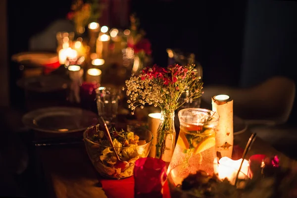 Decorated table ready for dinner. Beautifully decorated table set with flowers, candles, plates and serviettes for wedding or another event in the restaurant.