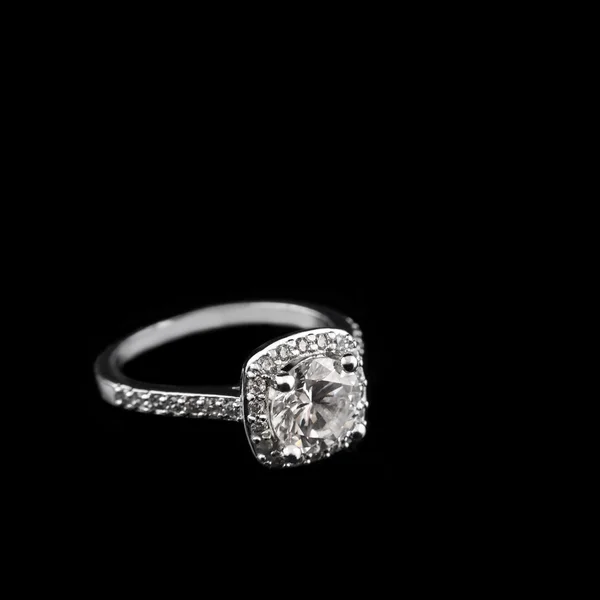 Luxury jewellery. White gold or silver engagement ring with diamonds closeup on black background. Selective focus. — Stock Photo, Image