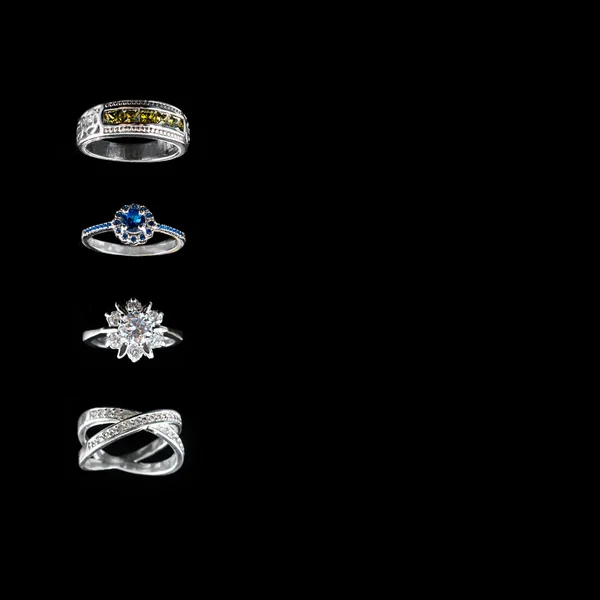 Collection of rings with colorful gems on black background. — Stock Photo, Image