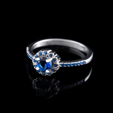 Lüks mücevher. Beyaz altın veya gümüş nişan yüzüğü siyah arka plan üzerinde renkli değerli taş closeup ile. Seçici odak.