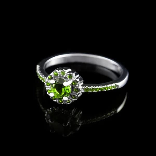 Luxury jewellery. White gold or silver engagement ring with colored gemstone closeup on black background. Selective focus. — Stock Photo, Image