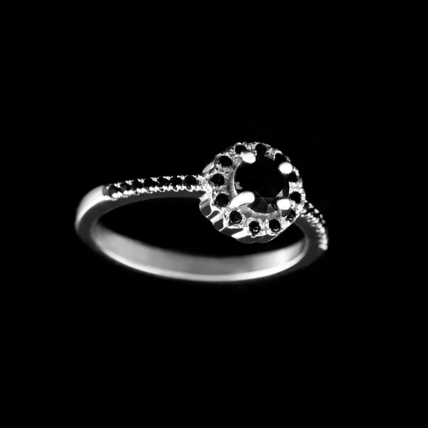 Luxury jewellery. White gold or silver engagement ring with colored gemstone closeup on black background. Selective focus. — Stock Photo, Image