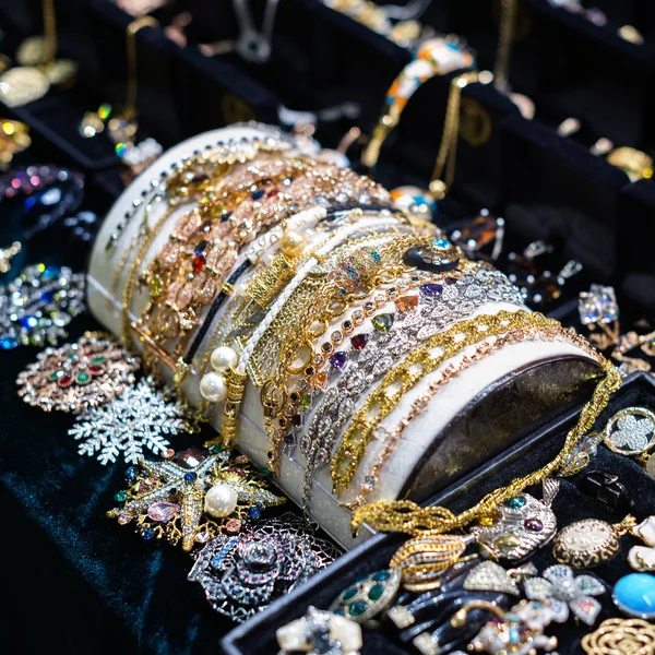 Verscheidenheid van sieraden in winkel venster. ringen, armbanden en oorbellen op fluweel staat te koop. — Stockfoto