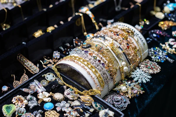 Utbud av smycken i store-fönstret. ringar, armband och örhängen på sammet står för försäljning. — Stockfoto