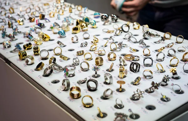 Variedad de joyas en escaparate. Anillos en las gradas en venta . — Foto de Stock