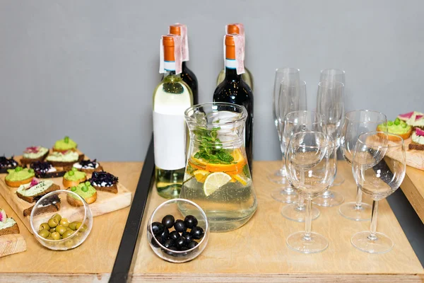 赤と白ワインとミントとレモンのフルーティーなドリンクのデカンタとティー テーブルの上の宴会で前菜の木製トレイ。美しい内装のレストランでテーブル セット. — ストック写真