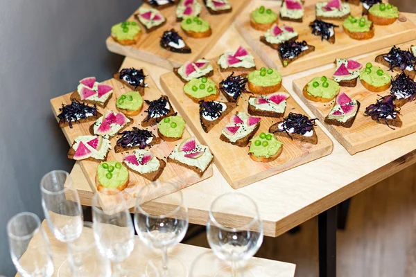 Bandeja de madera de aperitivos vegetarianos en la mesa de centro de la plataforma en el banquete . —  Fotos de Stock