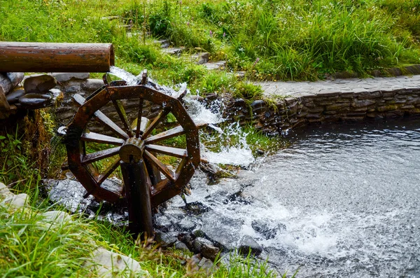 Working watermill wheel with falling waterin the village. — Stock Photo, Image